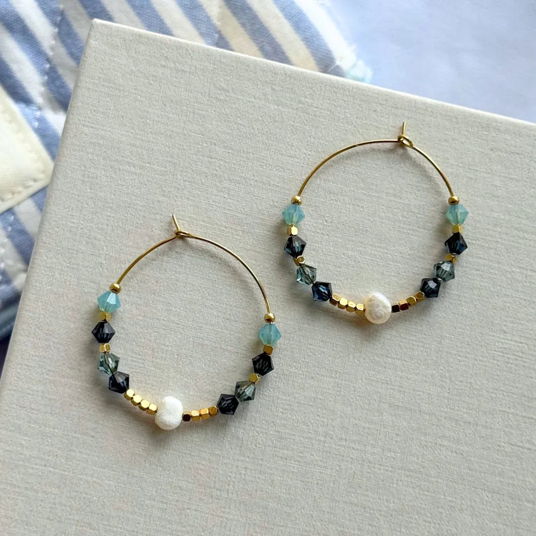 Paire de boucles d'oreilles créoles en acier inoxydable doré, ornées d'une perle blanche, de perles facettées bleues et