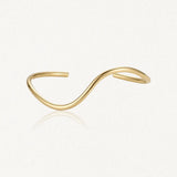 Bracelet jonc ouvert minimaliste en acier inoxydable doré, à double vague asymétrique.