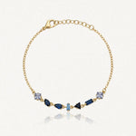 Bracelet Blair en acier inoxydable doré avec une fine chaîne et des strass en zirconium de différentes formes et bleus