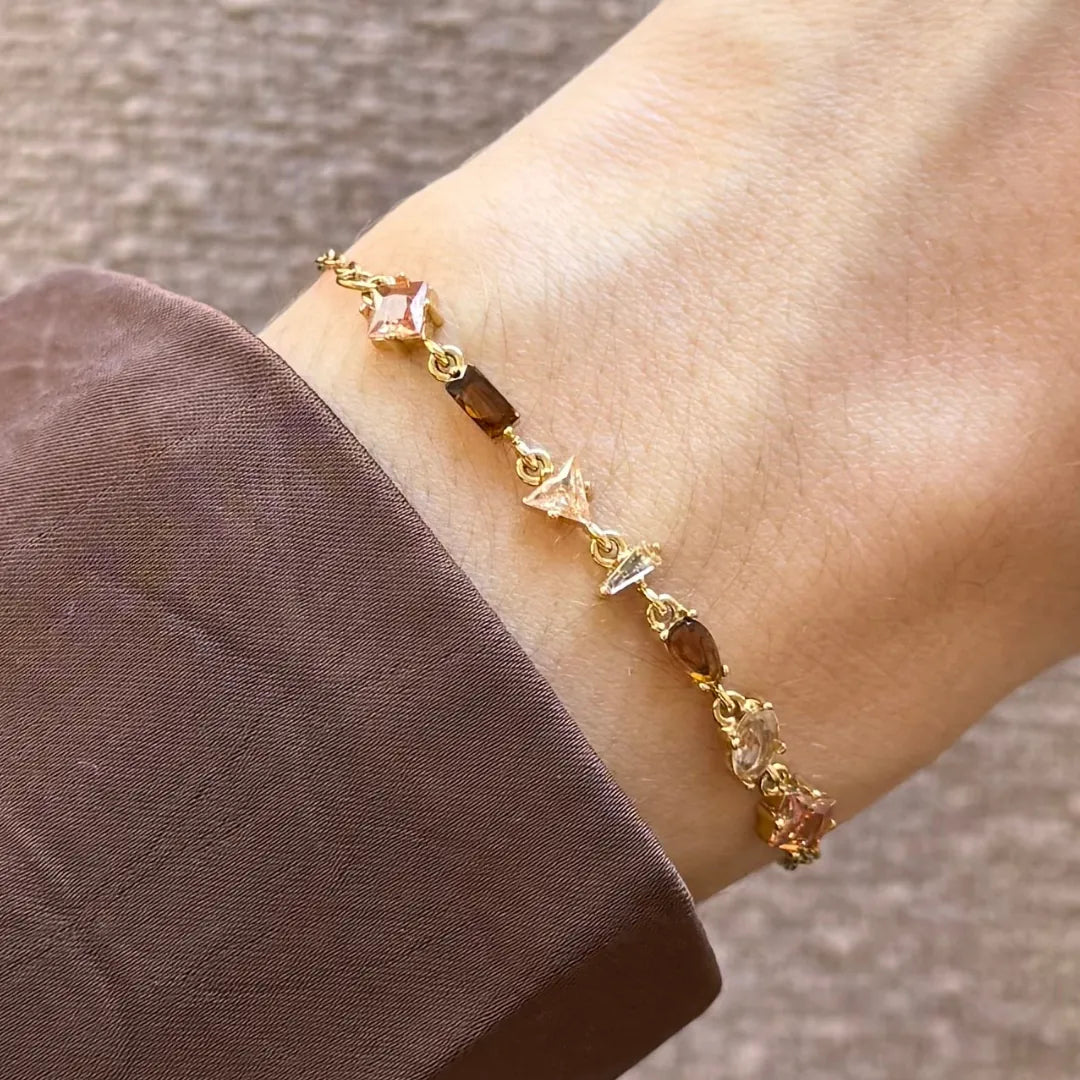 Bracelet Blair en acier inoxydable doré orné de strass en zirconium de formes géométriques variées sur un poignet