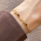 Bracelet Blair en acier inoxydable doré orné de strass en zirconium de formes géométriques variées sur un poignet