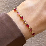 Bracelet Blair en acier inoxydable doré orné de strass en zirconium de différentes formes et teintes de rouge et rose