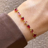 Bracelet Blair en acier inoxydable doré orné de strass en zirconium de différentes formes et teintes de rouge et rose