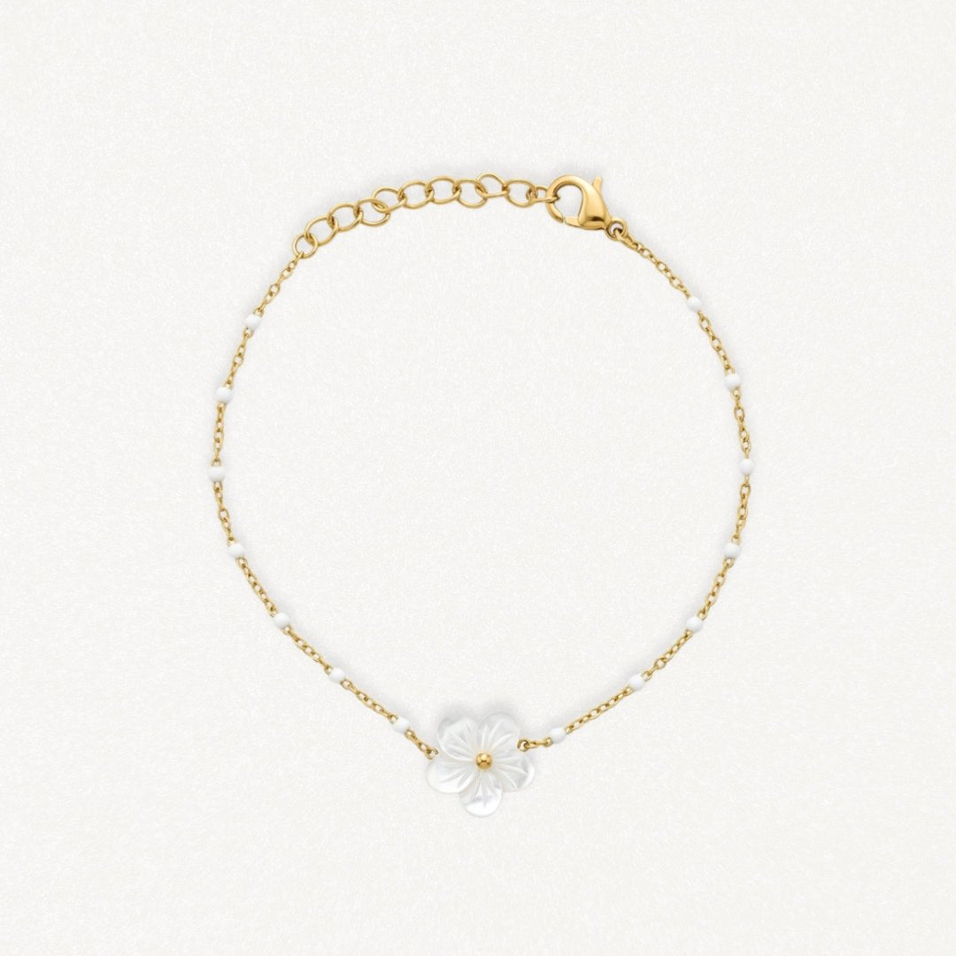 Bracelet en acier inoxydable doré avec chaîne perlée blanche et fleur de nacre.