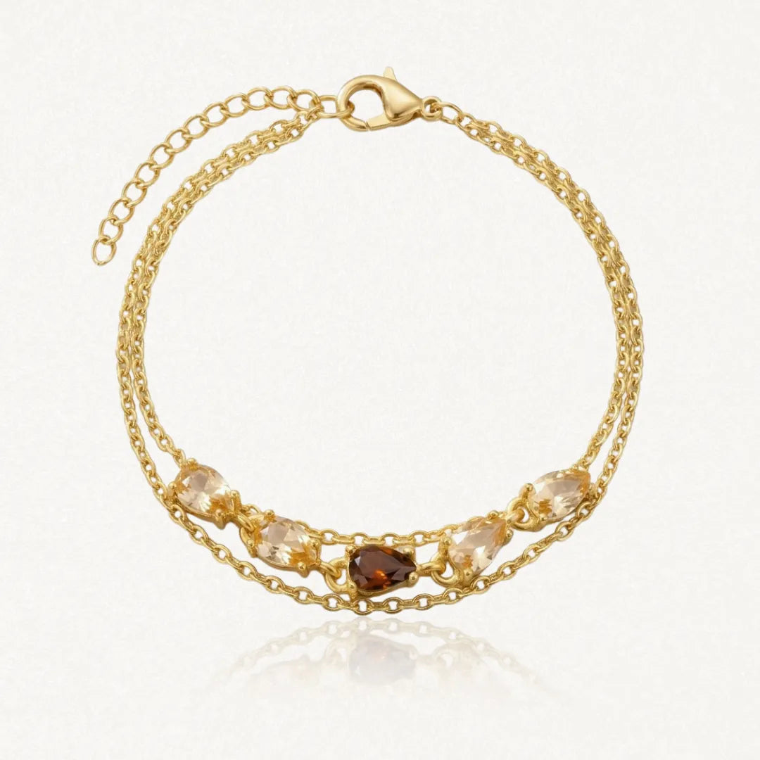 Bracelet double chaîne à maillons en acier inoxydable doré, avec zircons champagne et un zircon marron au centre.