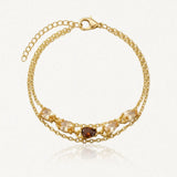 Bracelet double chaîne à maillons en acier inoxydable doré, avec zircons champagne et un zircon marron au centre.
