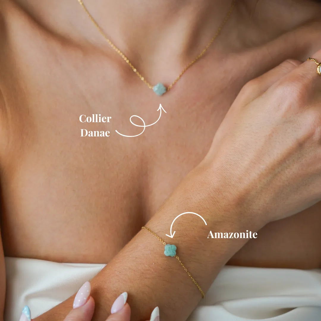 Une femme porte un collier et un bracelet fins en acier inoxydable doré, tous deux ornés d'une pierre naturelle d'Amazonite