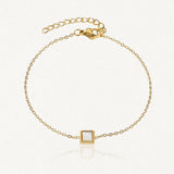 Bracelet fin en acier inoxydable doré avec un pendentif carré en Jade Blanc et une chaînette réglable.