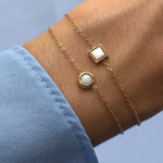 Deux bracelets fins en acier inoxydable doré, l'un avec un carré de Jade Blanc, l'autre avec une pierre naturelle ronde.