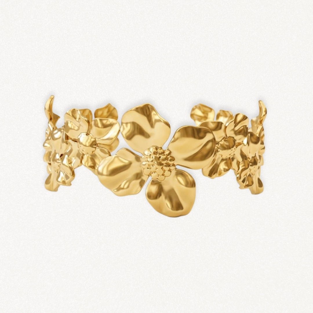 Bracelet rigide en acier inoxydable doré, motif floral avec fleurs aux centres texturés et feuilles.