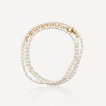 Bracelet multirang en perles d'eau douce ovales blanches avec fermoir et chaîne d'extension en acier inoxydable doré.