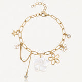Bracelet chaîne doré à maillons allongés avec 6 pendentifs : grande fleur nacrée, 2 fleurs dorées, étoile, perle et 2