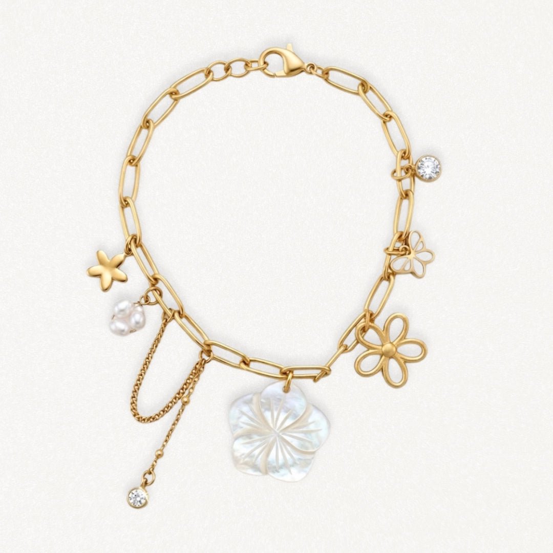 Bracelet en acier inoxydable doré avec chaîne à maillons, charms fleur nacre, perles, étoile de mer et zircons scintillants.
