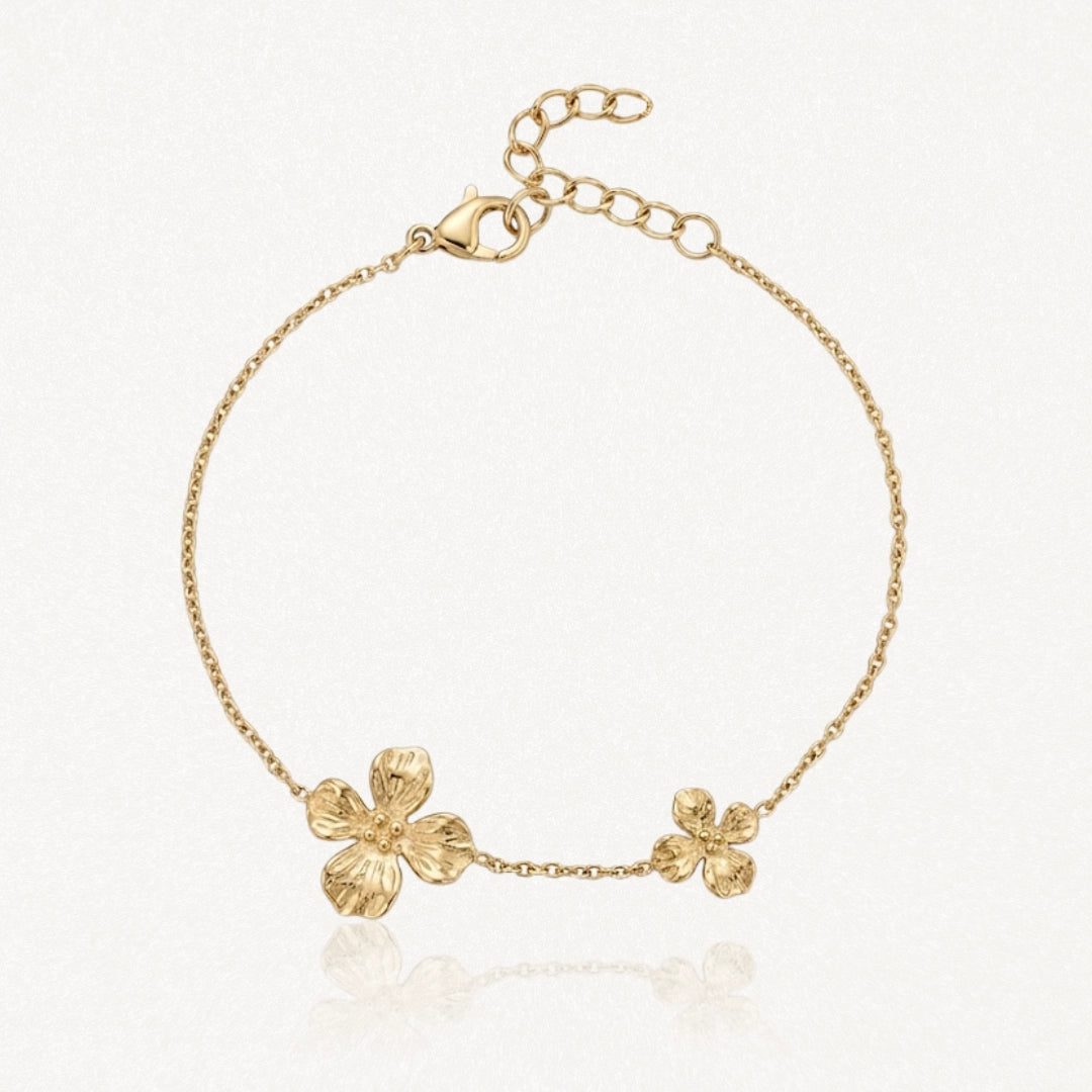 Bracelet chaîne doré avec deux fleurs texturées, une grande et une plus petite, et un fermoir mousqueton ajustable.