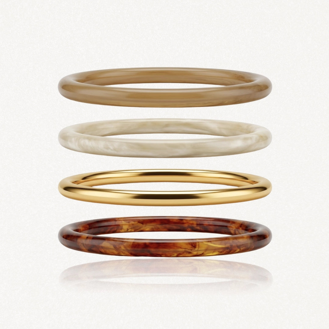 Lot de 4 bracelets joncs en acier inoxydable: doré, marron clair, beige marbré et marron écaille de tortue. Styles variés.