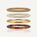 Lot de 4 bracelets joncs en acier inoxydable: doré, marron clair, beige marbré et marron écaille de tortue. Styles variés.