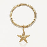 Bracelet jonc marbré crème et or avec un pendentif étoile de mer dorée texturée.