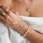 Bracelet fin en acier inoxydable doré, avec des perles d'apatite bleues et des perles blanches, porté au poignet.