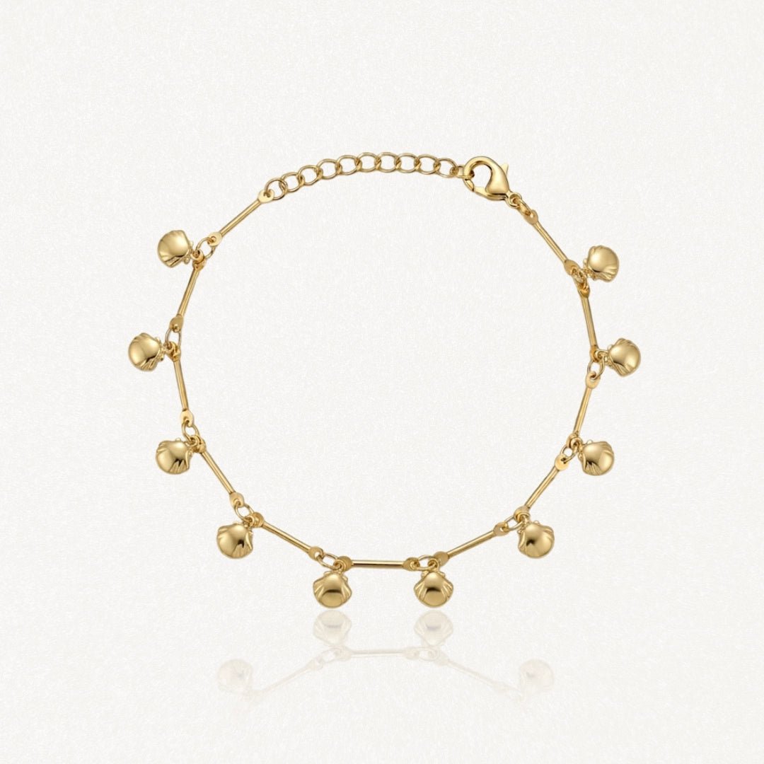 Bracelet en acier inoxydable doré orné de petits pendentifs coquillages et de barres fines. Chaîne ajustable.