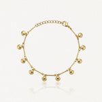 Bracelet en acier inoxydable doré orné de petits pendentifs coquillages et de barres fines. Chaîne ajustable.