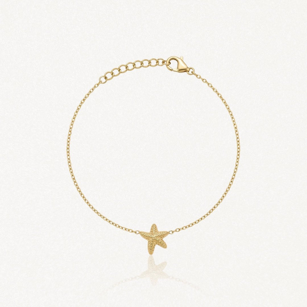 Bracelet fin en acier inoxydable doré, avec une étoile de mer texturée en pendentif et une chaîne réglable.