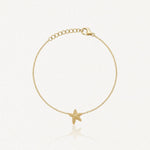 Bracelet fin en acier inoxydable doré, avec une étoile de mer texturée en pendentif et une chaîne réglable.