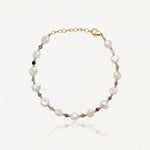 Bracelet en acier inoxydable doré avec perles de culture baroques blanches et petites pierres précieuses colorées.