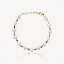 Bracelet en acier inoxydable doré avec perles de culture baroques blanches et petites pierres précieuses colorées.