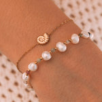 Bracelet en acier inoxydable doré chaîne fine avec coquillage nautilus. Bracelet perles baroques blanches, vertes et dorées.