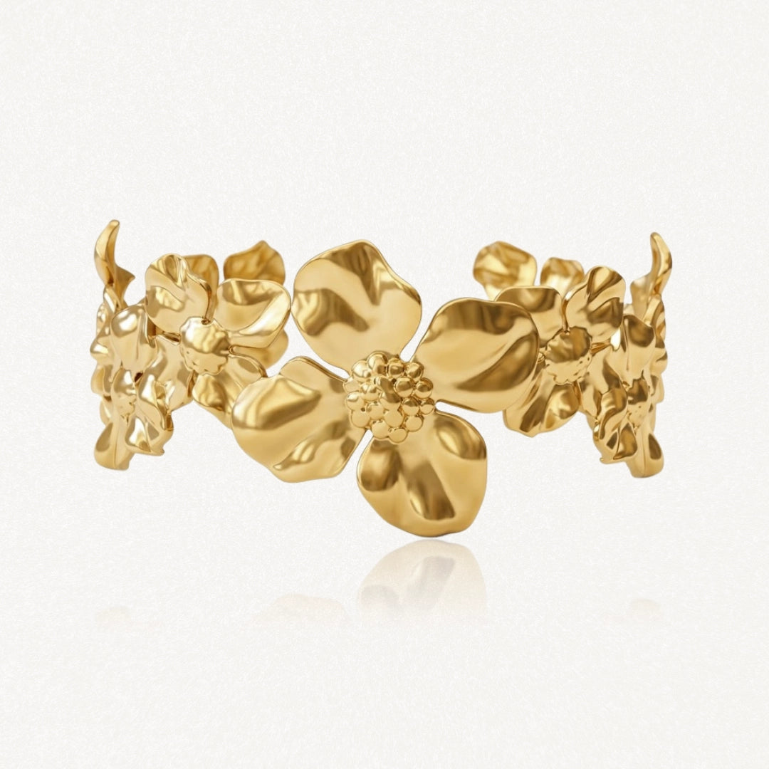Bracelet doré de style manchette, orné de multiples fleurs en relief aux centres texturés.