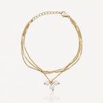 Bracelet doré à trois chaînes fines à maillons plats, fermoir mousqueton, chaînette d'extension et trois perles baroques