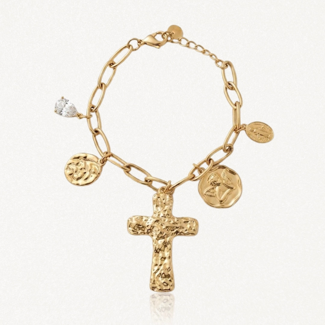 Bracelet à maillons dorés avec une grande croix texturée, un pendentif goutte en cristal et trois médailles variées.