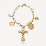 Bracelet à maillons dorés avec une grande croix texturée, un pendentif goutte en cristal et trois médailles variées.