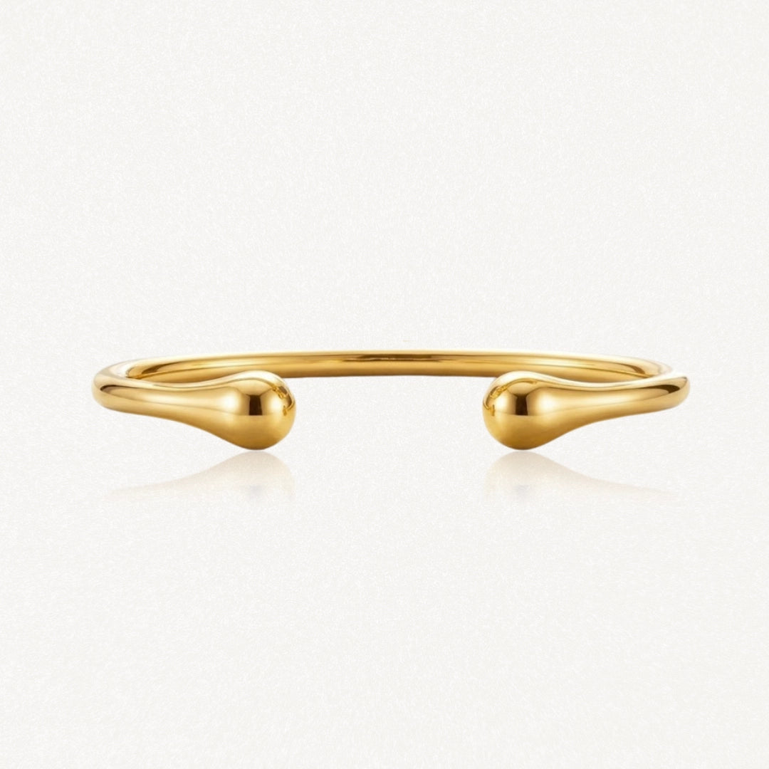 Bracelet jonc ouvert doré, poli et brillant, aux extrémités en forme de goutte.