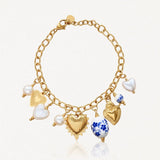 Bracelet à breloques en acier inoxydable doré, avec cœurs, perles blanches, nacre et pendentifs floraux en céramique.
