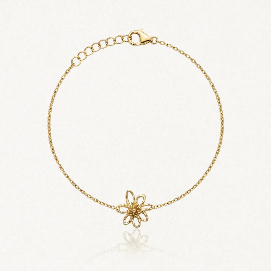 Bracelet fin en acier inoxydable doré, pendentif fleur ajourée cœur granuleux, fermoir mousqueton et chaînette de réglage.