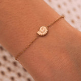 Bracelet fin acier inoxydable doré, pendentif coquillage nautilus sur poignet.