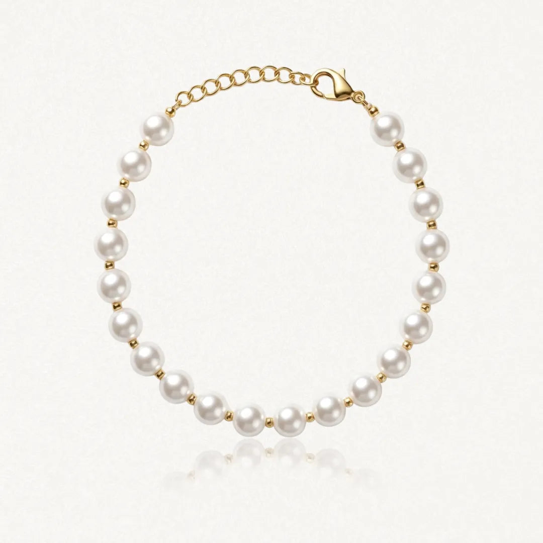 Bracelet de perles blanches rondes alternant avec des petites perles en acier inoxydable doré, fermoir mousqueton.