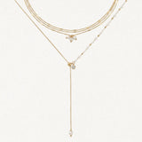 Composition de colliers en acier inoxydable doré: ras-le-cou triple chaîne avec perles irrégulières et collier en Y perlé.