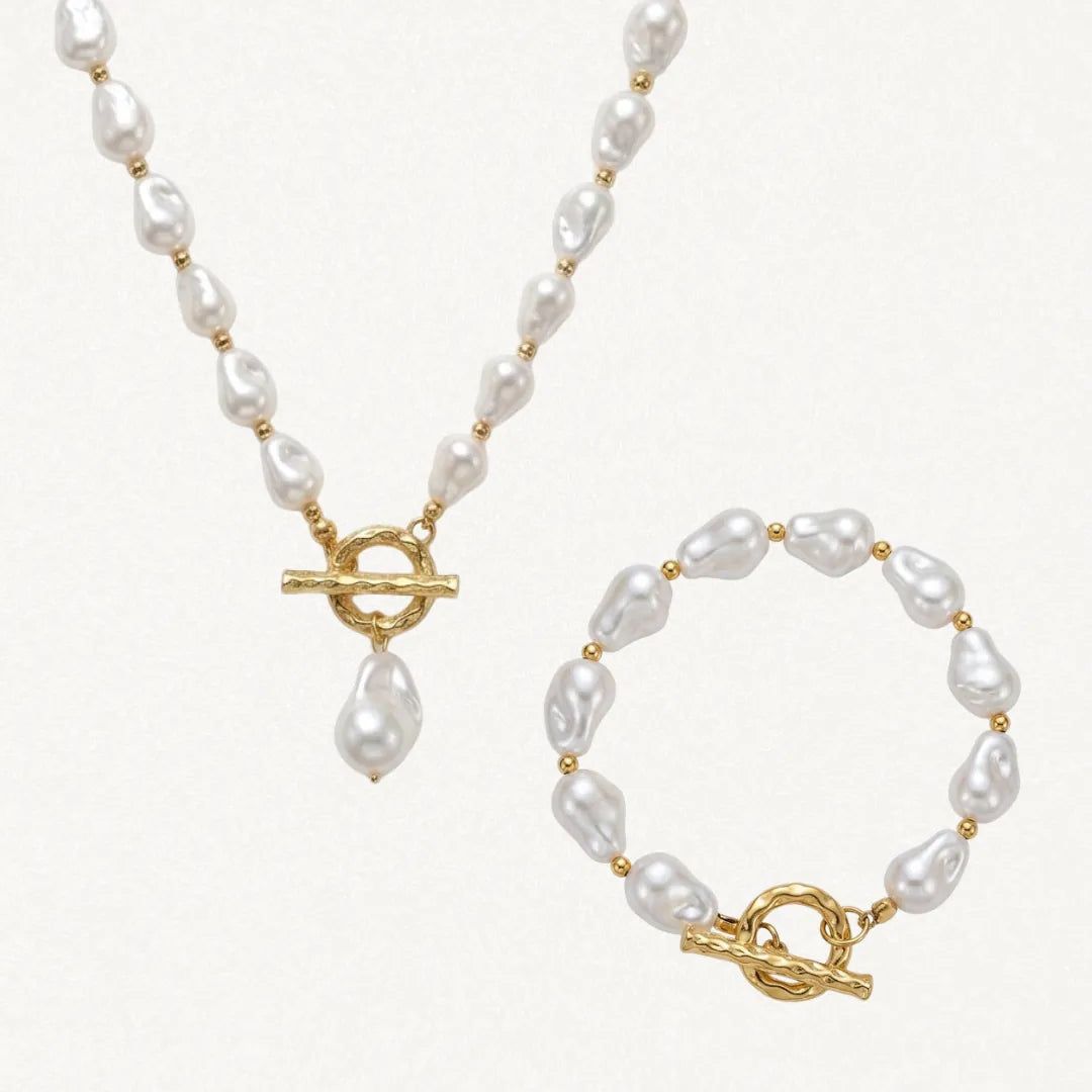 Collier et bracelet assortis en perles baroques blanches et acier inoxydable doré, avec fermoirs toggle texturés.