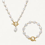Collier et bracelet assortis en perles baroques blanches et acier inoxydable doré, avec fermoirs toggle texturés.