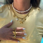 Collier double: un rang de perles, un rang chaîne en acier inoxydable doré avec charms étoiles de mer et coquillages.