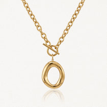 Collier en acier inoxydable doré, chaîne à gros maillons, fermoir toggle et pendentif ovale irrégulier brillant.