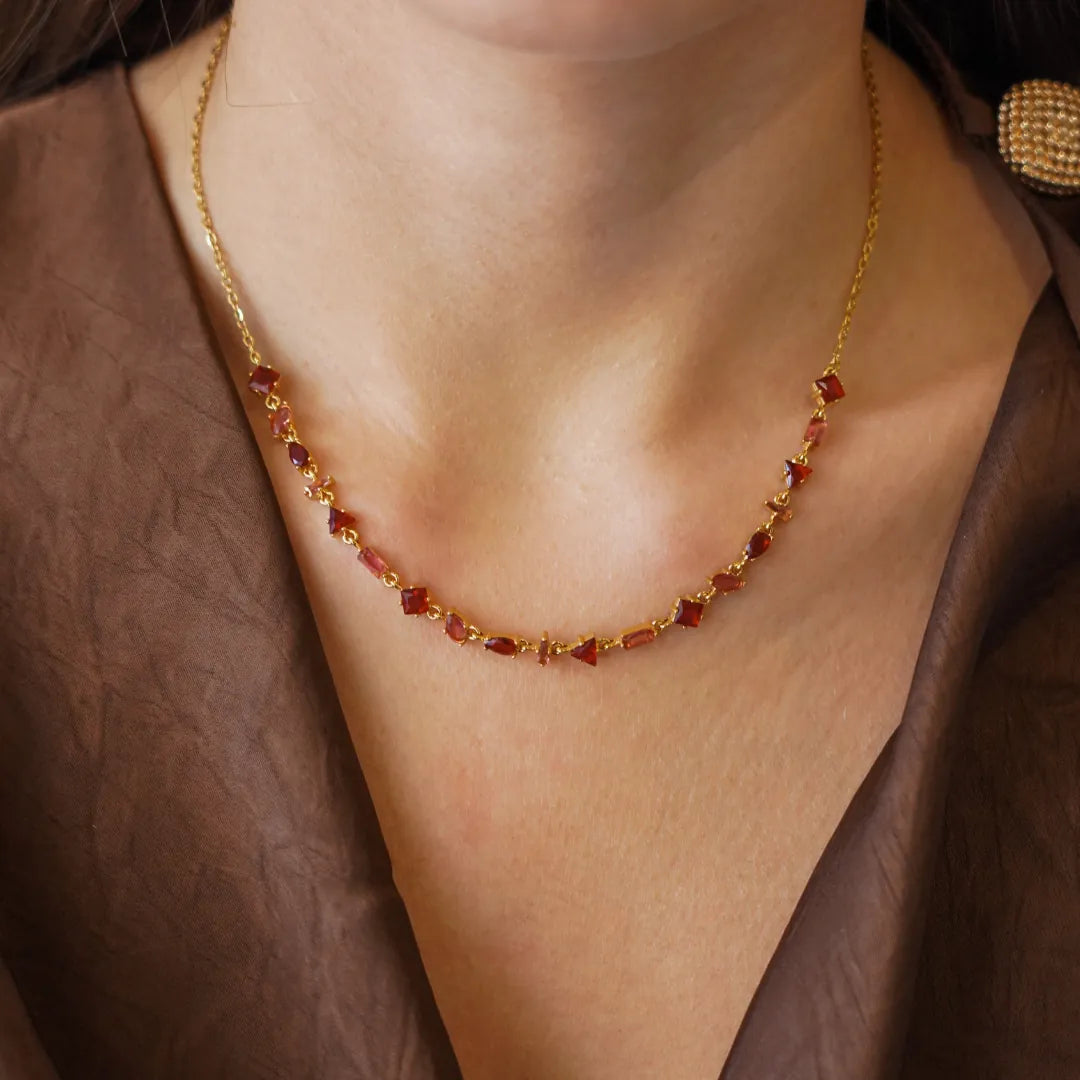 Collier Blair en acier inoxydable doré avec des strass en zirconium de couleur rouge portés autour du cou