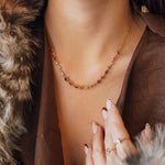 Collier Blair en acier inoxydable doré avec des strass en zirconium violets et transparents portés autour du cou