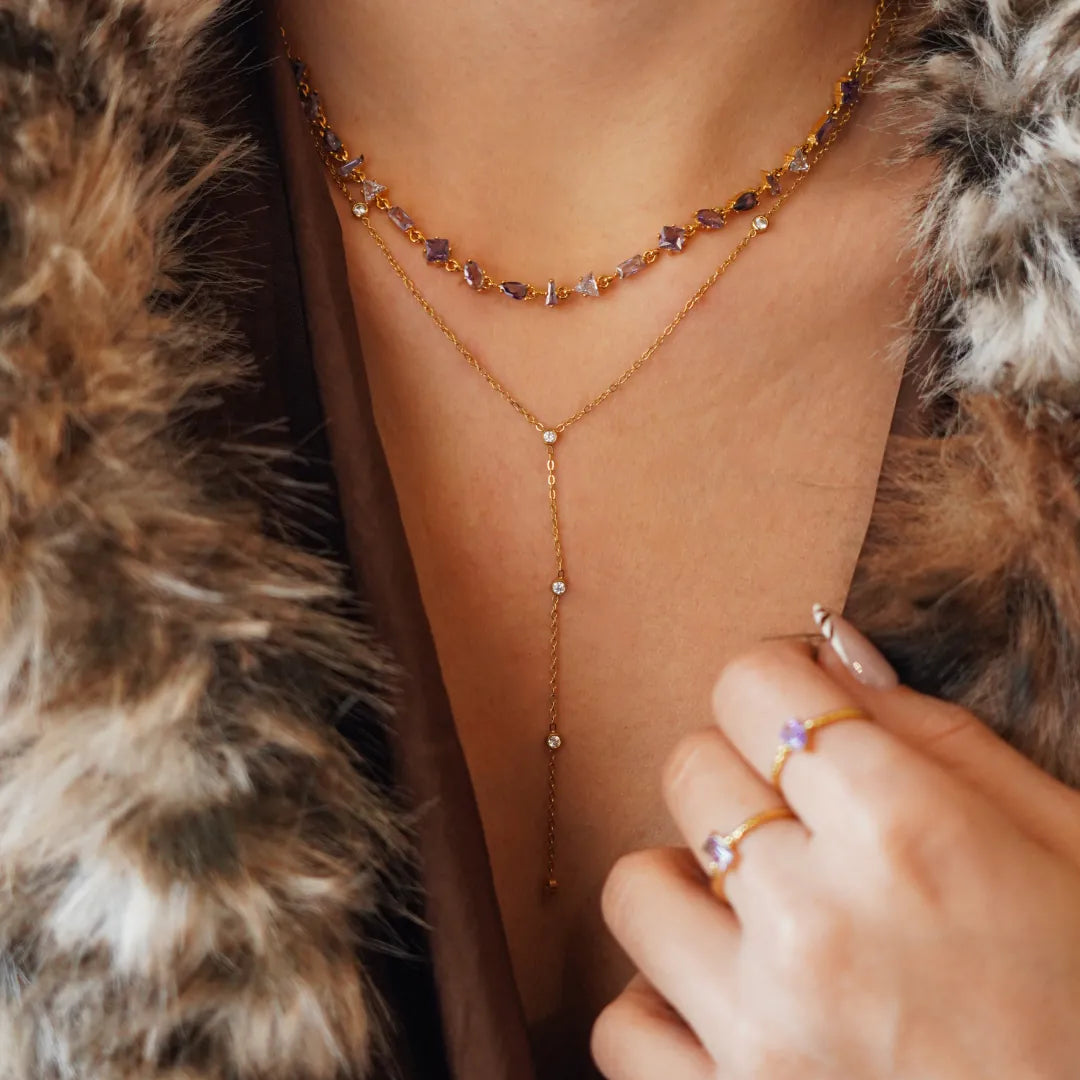 Collier Blair en acier inoxydable doré avec des strass en zirconium violets et transparents portés autour du cou
