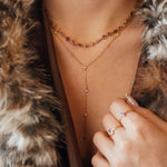 Collier Blair en acier inoxydable doré avec des strass en zirconium violets et transparents portés autour du cou
