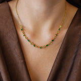 Collier Blair en acier inoxydable doré orné de strass en zirconium verts et jaune clair portés autour du cou