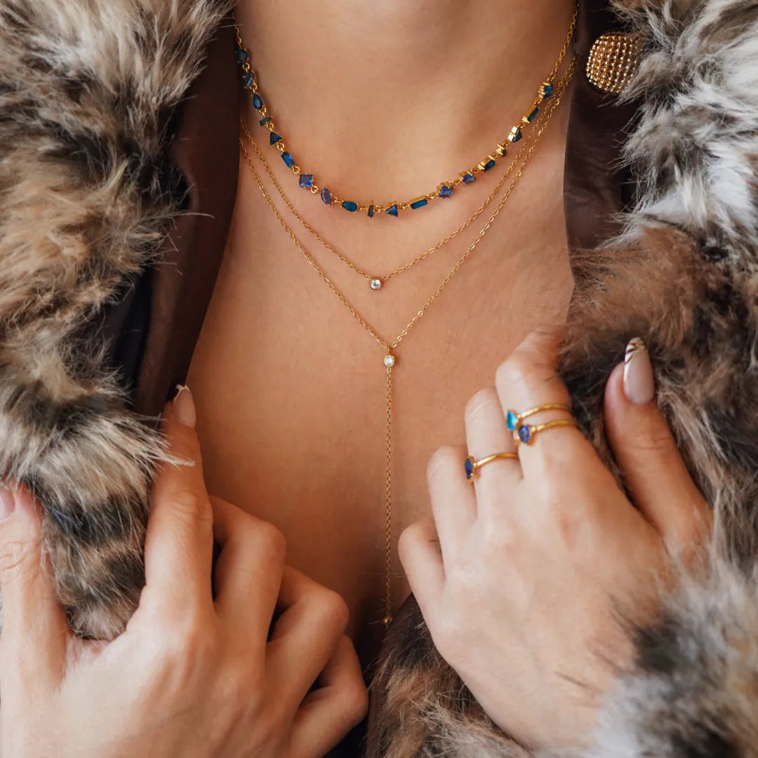 Collier Blair en acier inoxydable doré avec des strass en zirconium bleus et transparents portés autour du cou