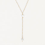 Collier lariat en acier inoxydable doré avec perles blanches, petits trèfles en nacre et billes dorées.